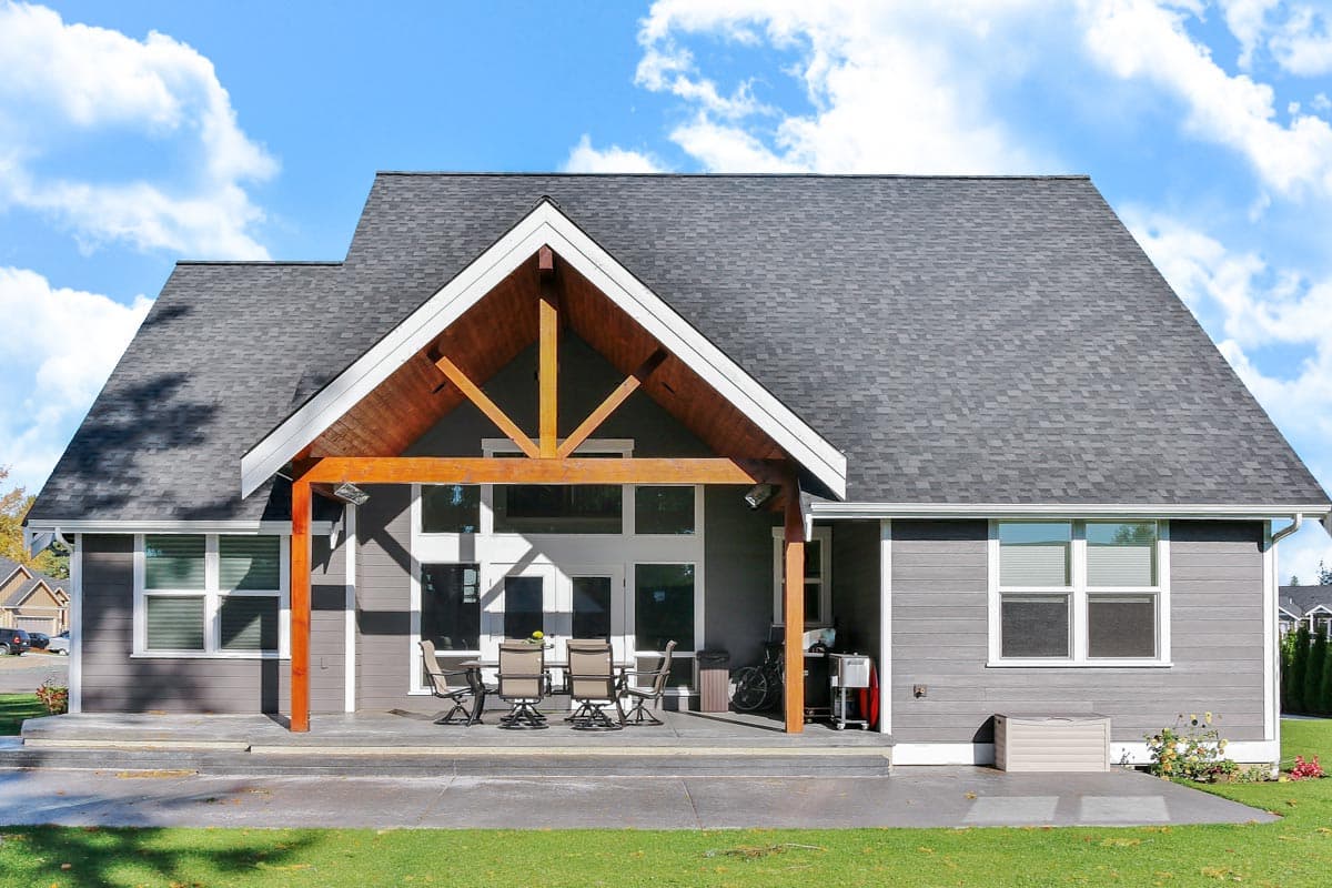 House plan exterior: single-story Modern Farmhouse with covered porch, exposed wood beams, gable roofline, and large windows.