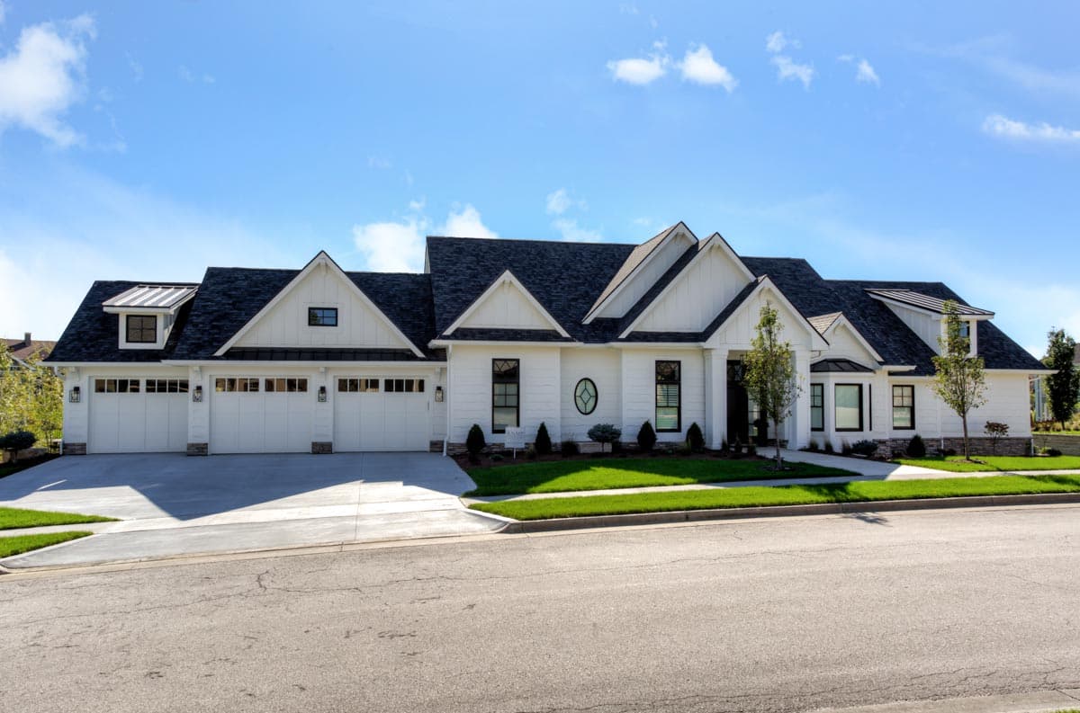 Modern Farmhouse style house plan exterior with a prominent gabled roof, a three-car garage, and board-and-batten siding.
