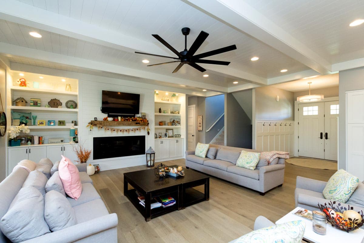 Living room with coffered ceiling, fireplace, built-in shelves, and double entry doors visible.