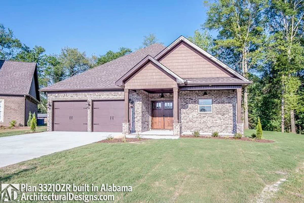 House plan exterior: Ranch style with a double garage, covered entry with wood beams, and brick facade.