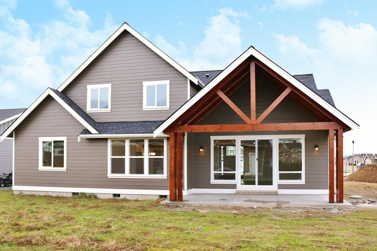 House plan exterior, two stories, with a covered patio featuring exposed wood beams and gabled roofline.