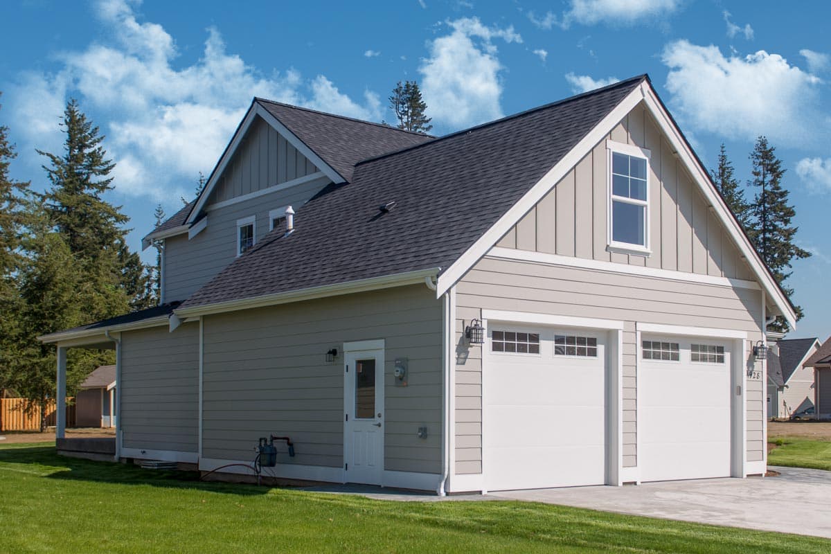 House plan exterior with two-car garage, gabled dormer, siding, and covered entryway.