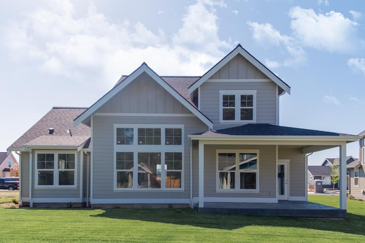 Modern Farmhouse house plan exterior with multiple gables, large windows, and a covered patio.
