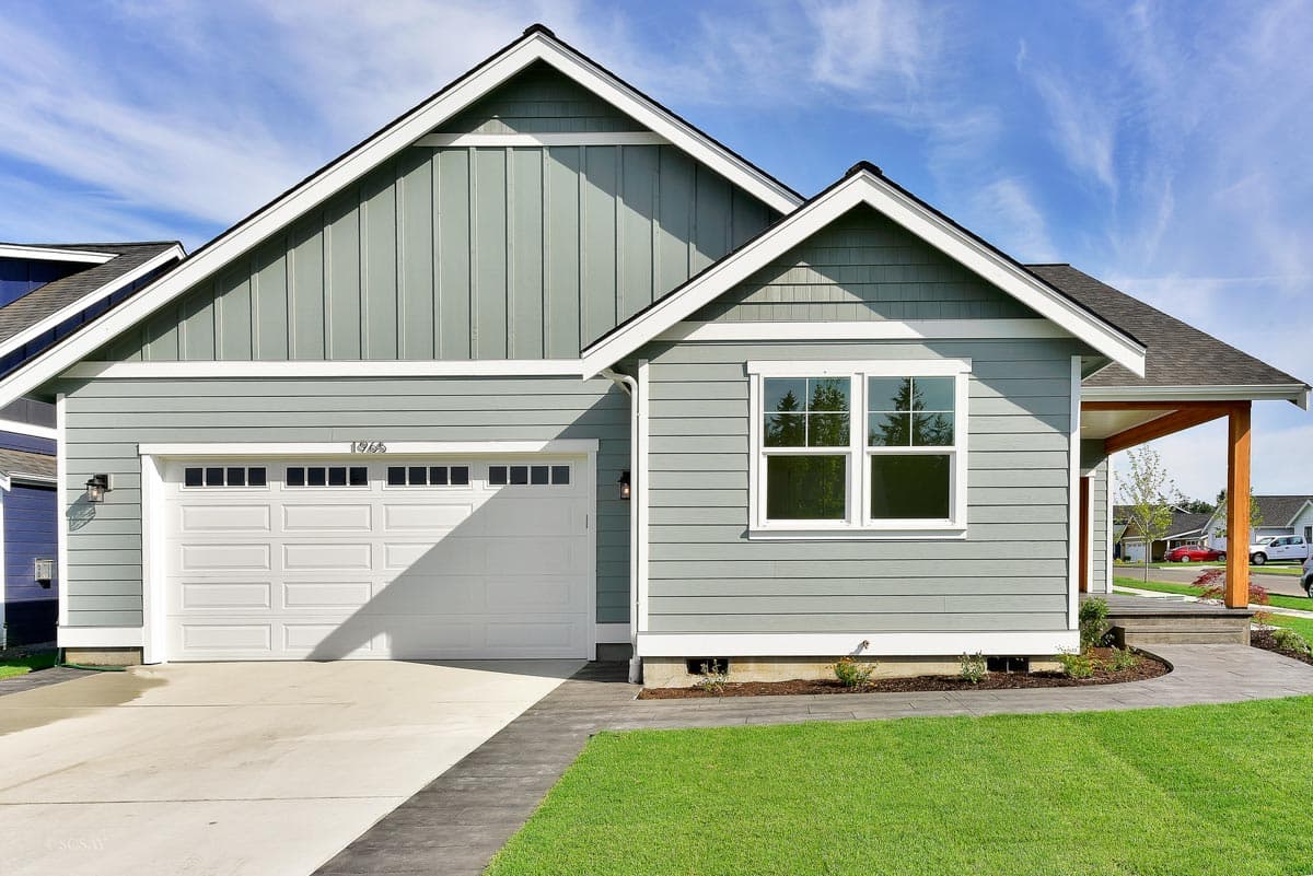 Modern Farmhouse style house plan exterior with horizontal siding, vertical gable siding, a two-car garage, and covered entry porch.
