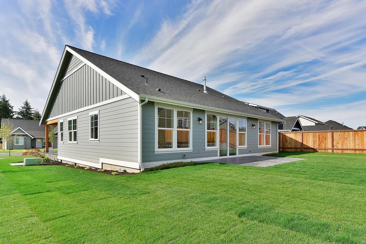 House plan exterior: Modern style, single-story home with horizontal siding, prominent gable end, and large windows.
