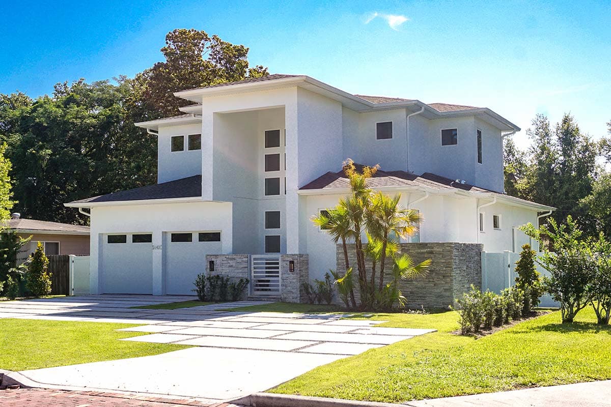 Modern two-story house plan exterior with a prominent entryway, three-car garage, and stone accent wall.