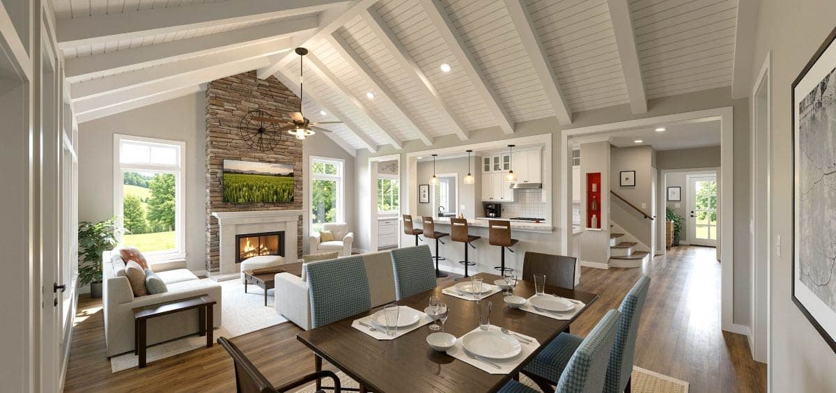 Open-concept living, dining, and kitchen area with vaulted ceilings, exposed beams, stone fireplace, and kitchen island.