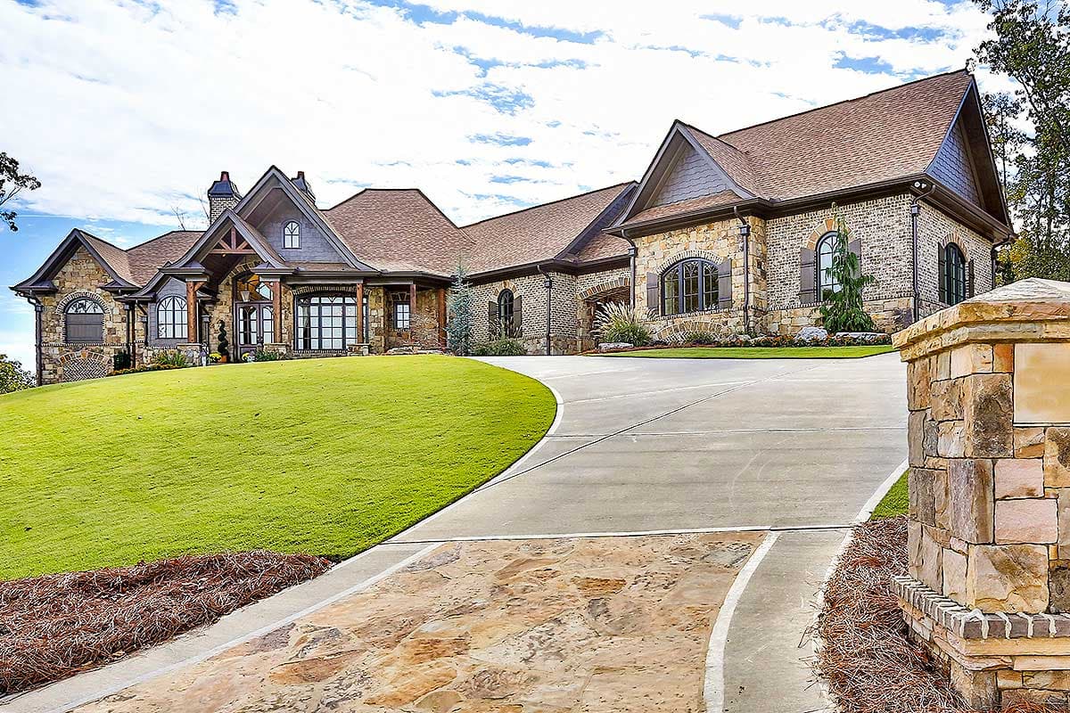 House plan exterior, Craftsman style, multiple gables, stone and brick facade, large windows, covered entry with wooden posts.