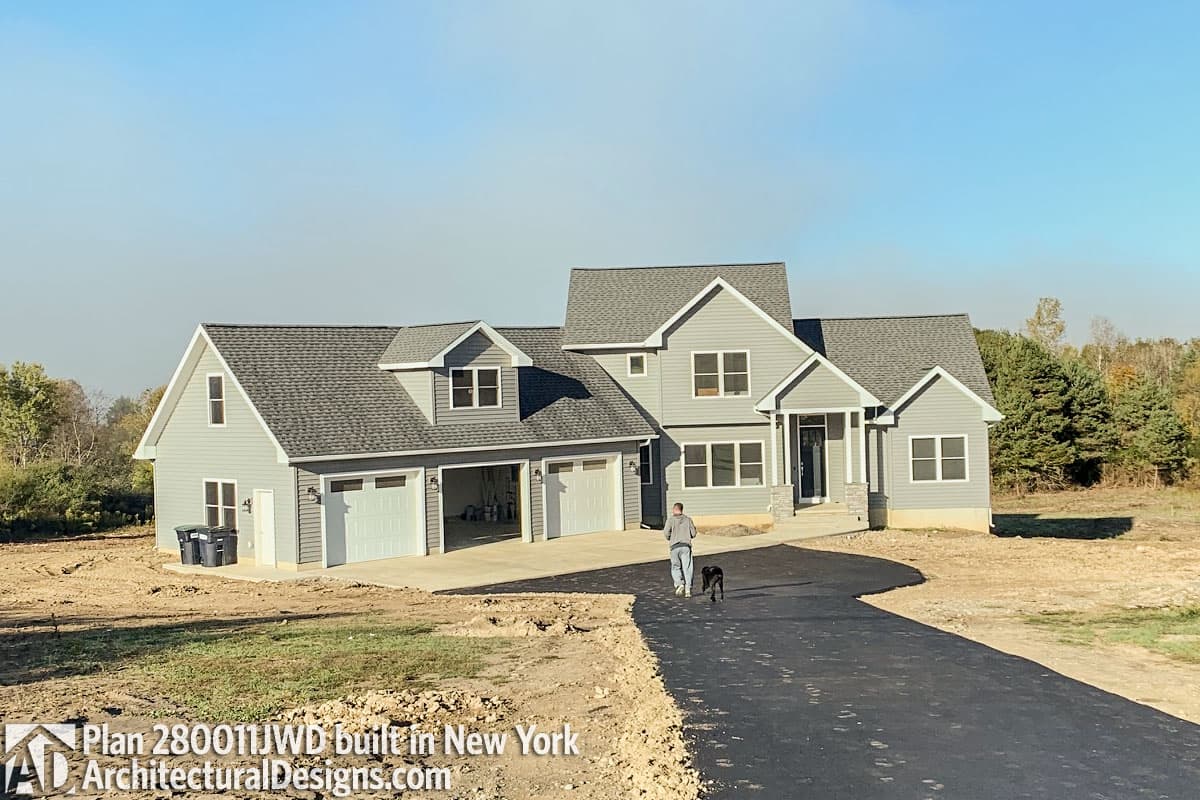 House plan exterior: Modern Farmhouse style, two stories, with a three-car garage, gables, and dormers.