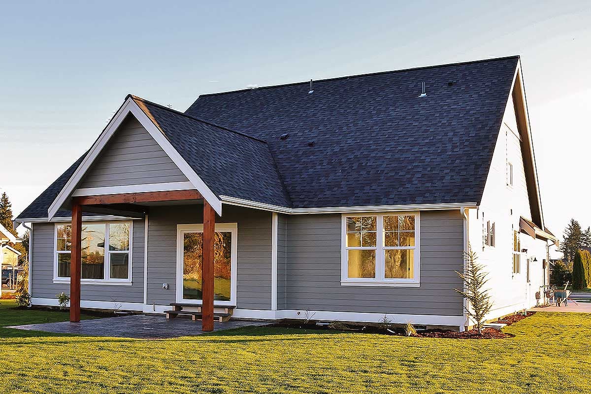House plan exterior: One-story home with covered porch, gabled rooflines, and vinyl siding.