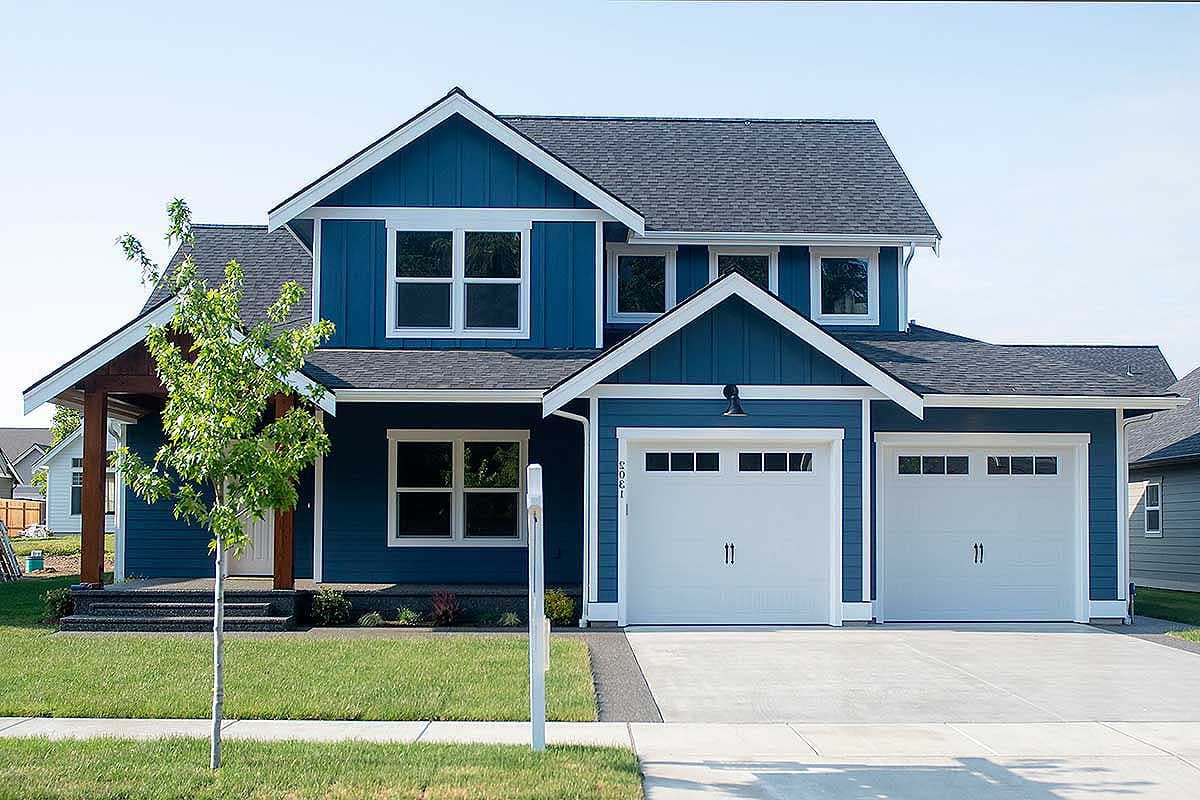 Modern Farmhouse house plan exterior with blue siding, dual garage doors, and prominent gables.