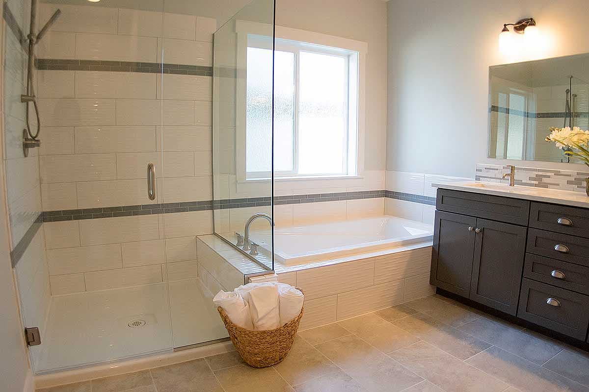 Contemporary bathroom featuring a glass-enclosed shower, soaking tub, and double vanity with dark wood cabinetry.