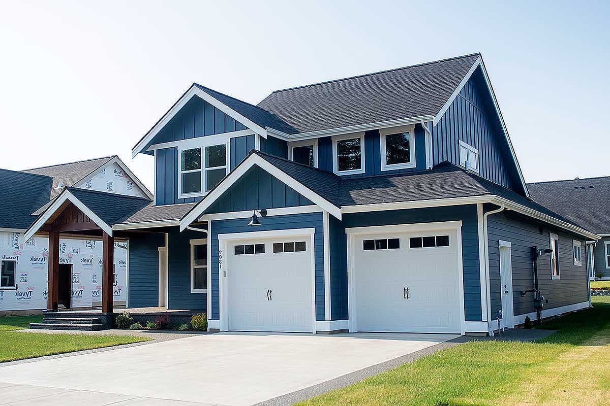 Modern Farmhouse house plan exterior with a two-story design, blue siding, and a three-car garage.