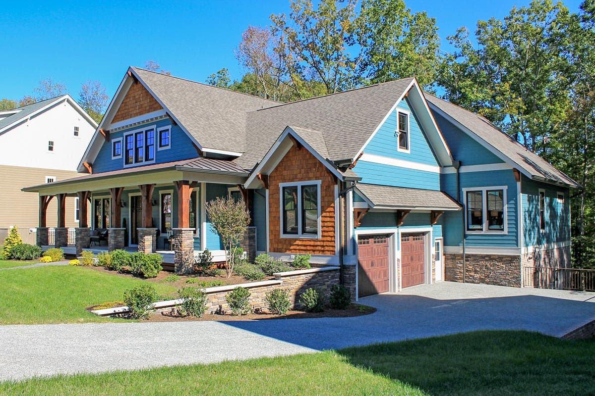 Craftsman house plan exterior with wrap-around porch, stone accents, cedar shake gable, and attached two-car garage.