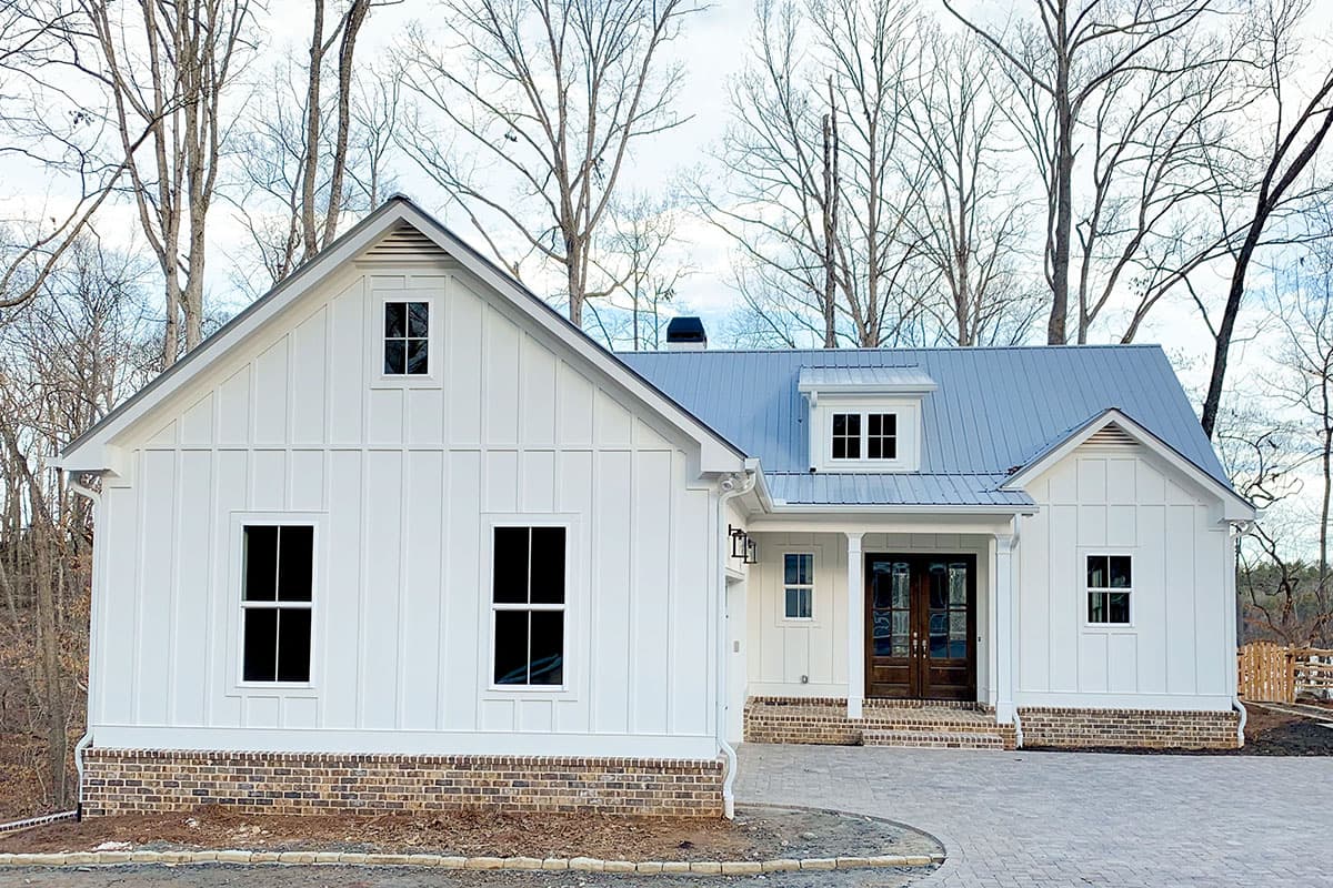 Modern Farmhouse house plan exterior with vertical siding, metal roof, gabled dormer, and covered entry.