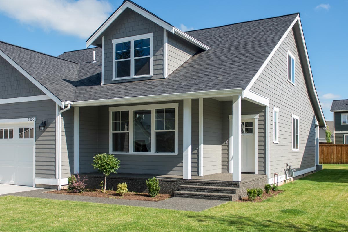 House plan exterior with gabled dormer, covered front porch, and attached garage.