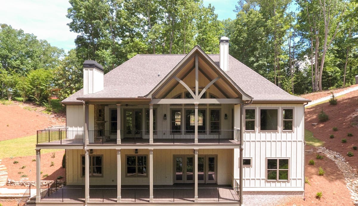 Modern Farmhouse house plan exterior with two stories, a prominent gable, covered balconies, and vertical siding.