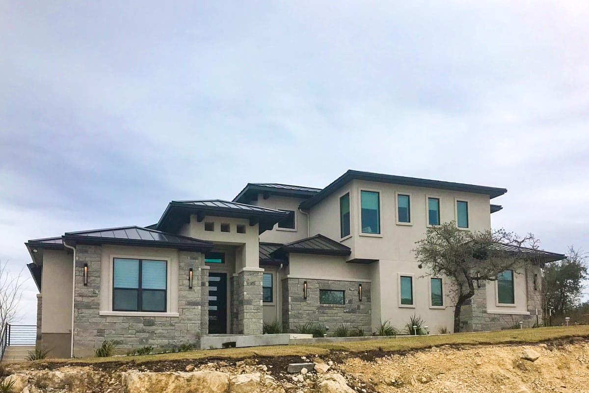 House plan exterior with two stories, flat roof, stone accents, and rectangular windows. Modern style home with a covered entry.