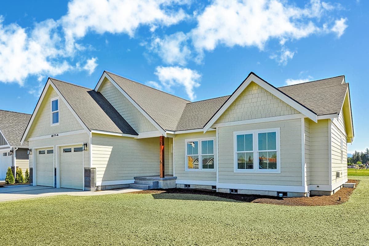House plan exterior: Single-story home with a wide front entrance, gabled dormers, and a side-facing three-car garage.