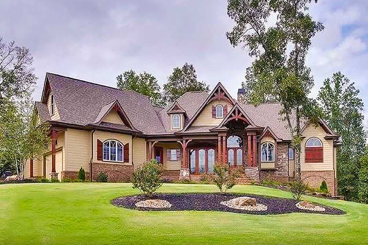 Craftsman style house plan exterior, two stories, featuring a wrap-around porch, prominent gables, and arched windows.