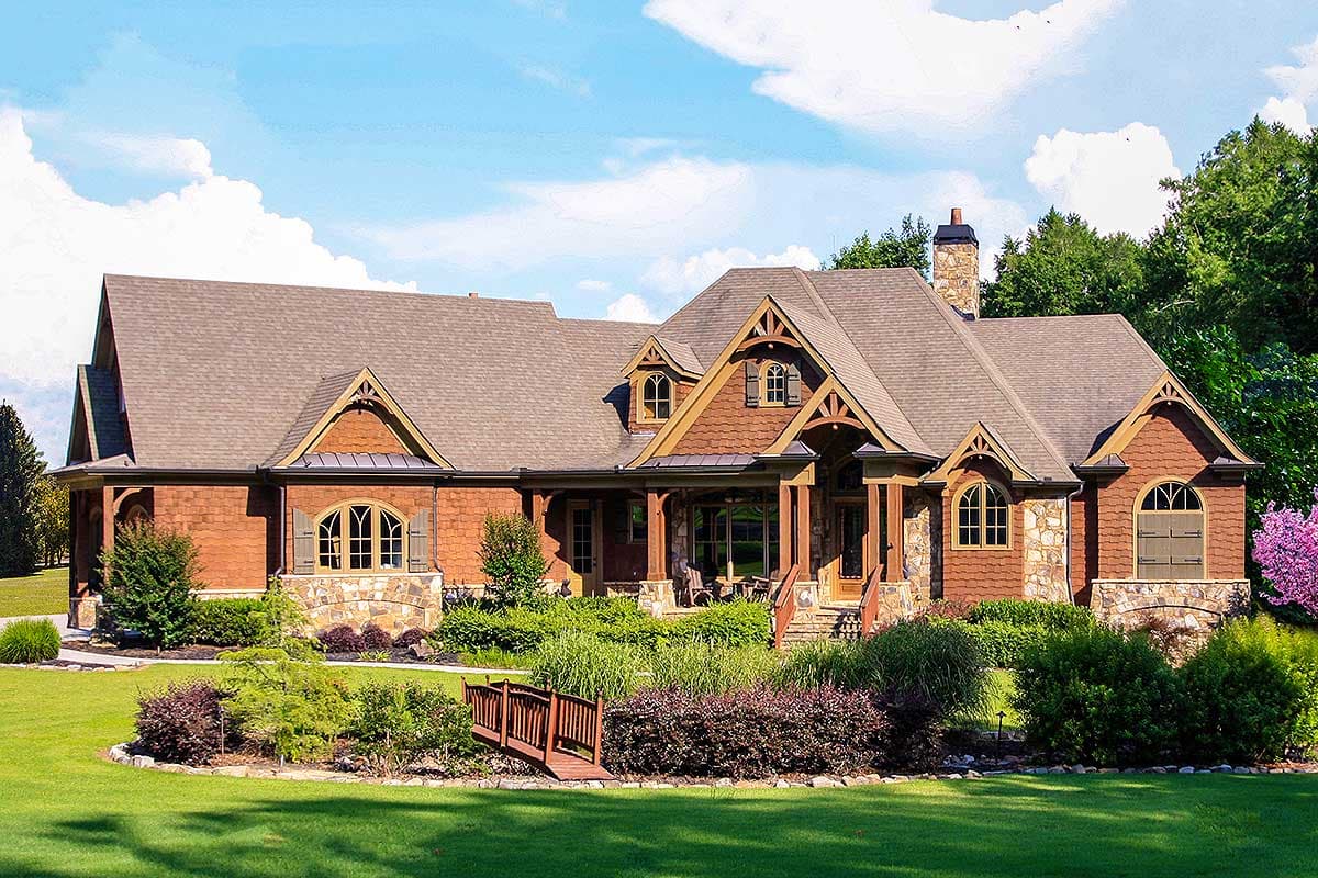 House plan exterior. Craftsman style with two stories, gabled rooflines, stone accents, and a covered porch. Dormers are present.