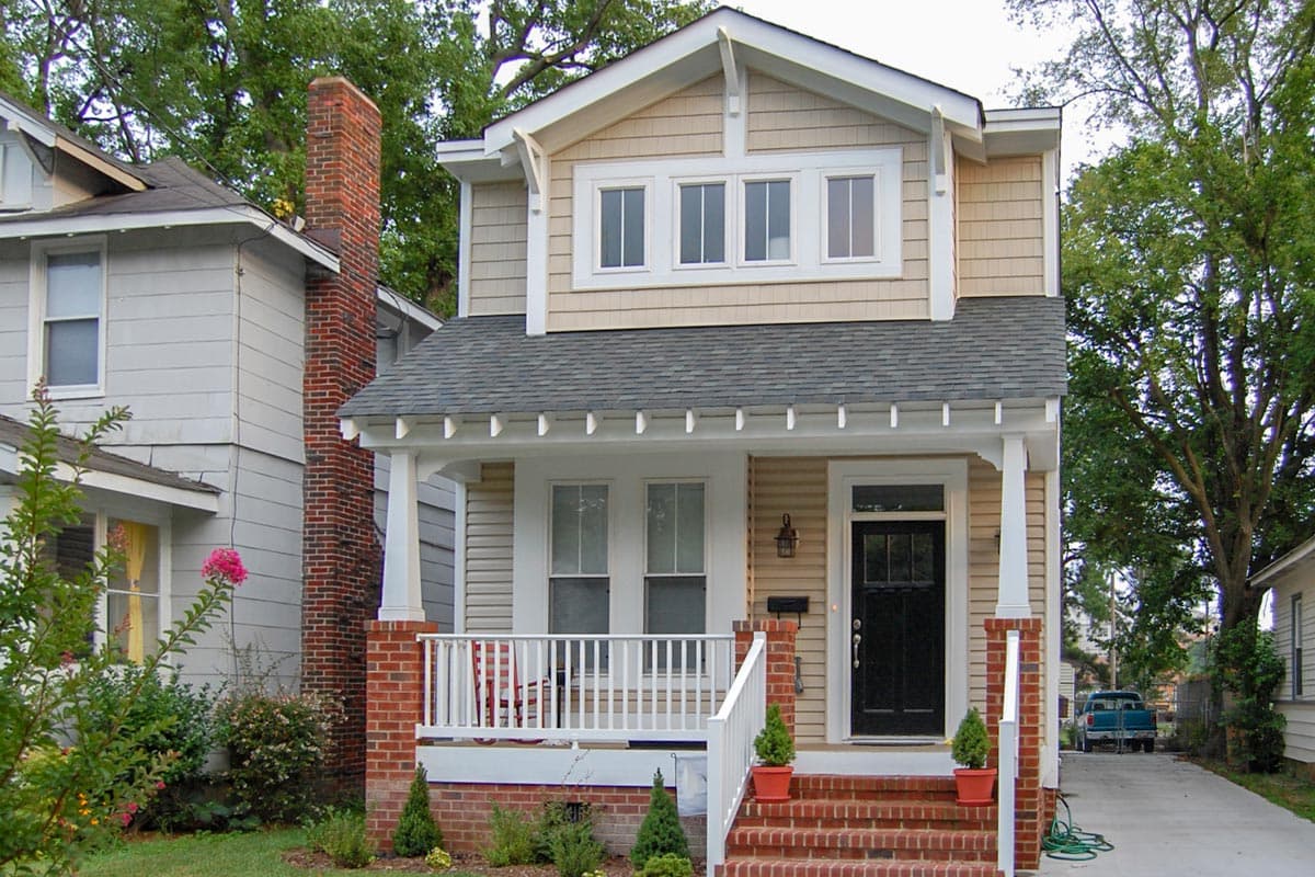 Two-story Craftsman house plan with front porch, brick chimney, and prominent gables.