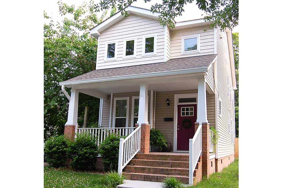 House plan exterior: two-story home with covered porch, brick foundation, gabled roof, and dormer windows.