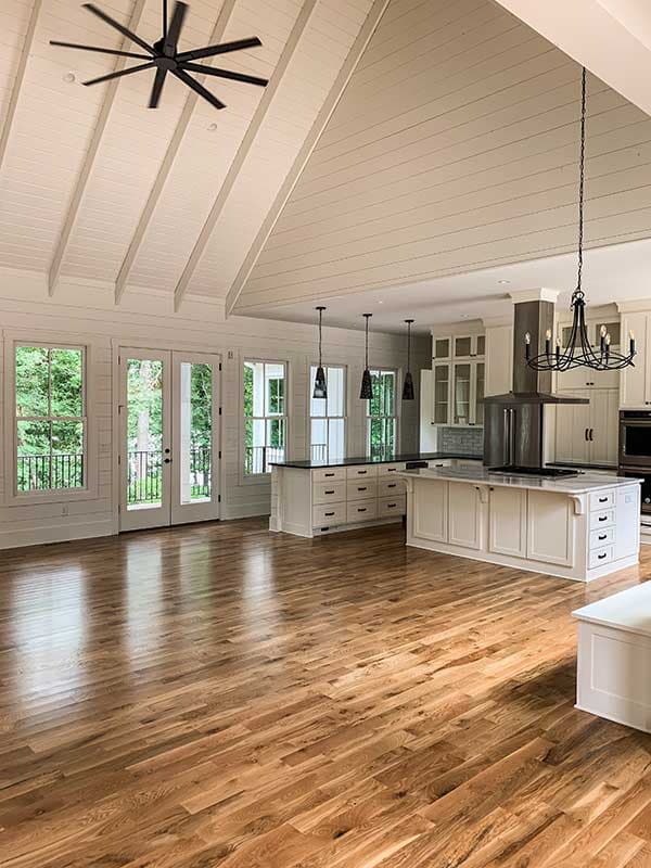 Open concept living area with vaulted wood-paneled ceiling, kitchen island, and hardwood floors.