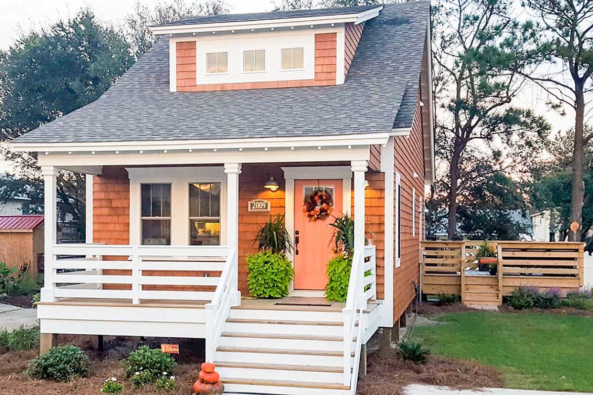 House plan exterior featuring a Craftsman style with a gabled roof, dormer, and front porch with pillars and railing. Two story.