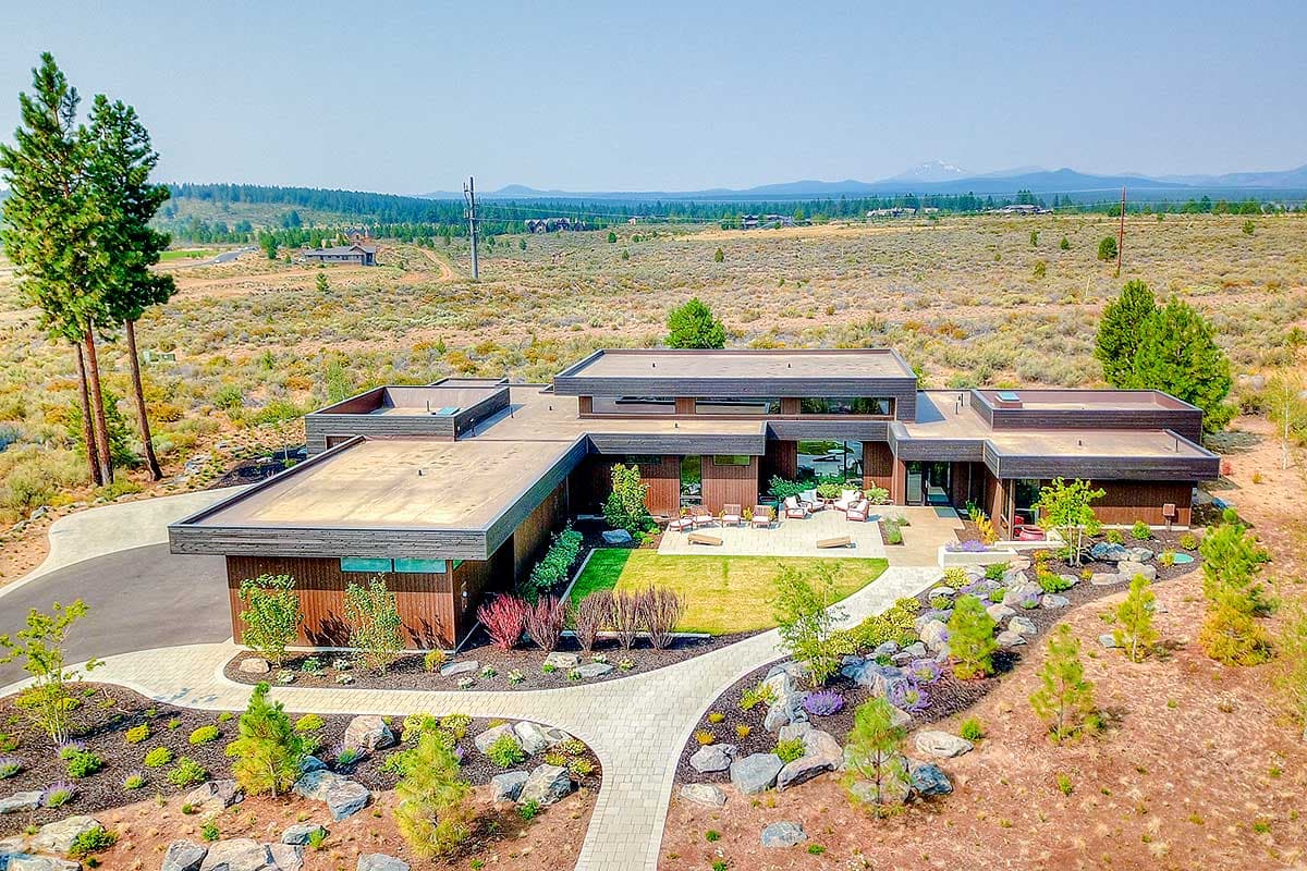 House plan exterior featuring a Modern style, flat roof, wood siding, and multiple rectangular building sections with a landscaped courtyard.