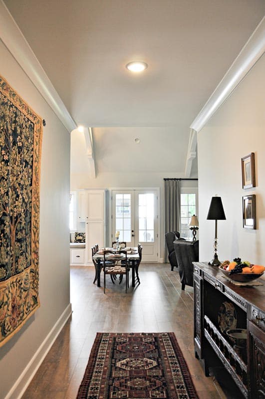 Interior view of dining area with French doors and built-in cabinets, adjacent to a living area.