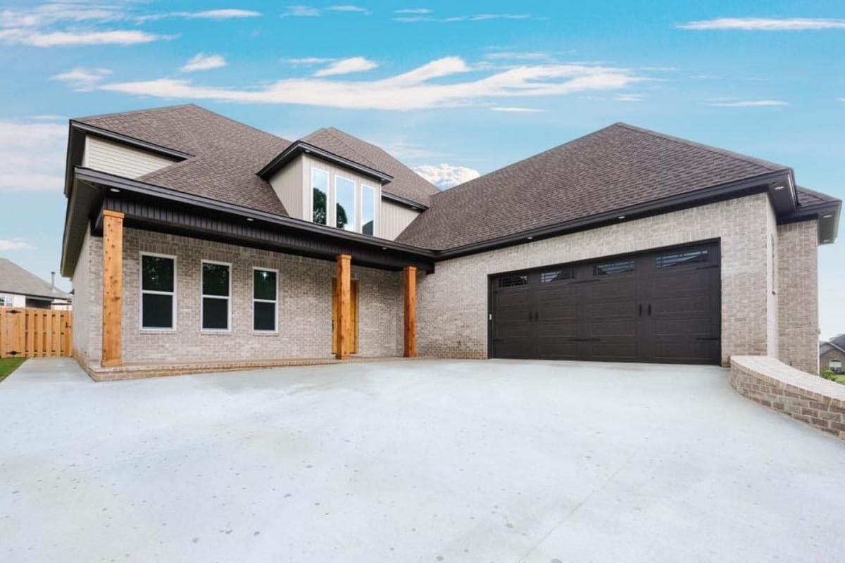 House plan exterior with brick facade, gabled roof, dormer, and attached two-car garage.
