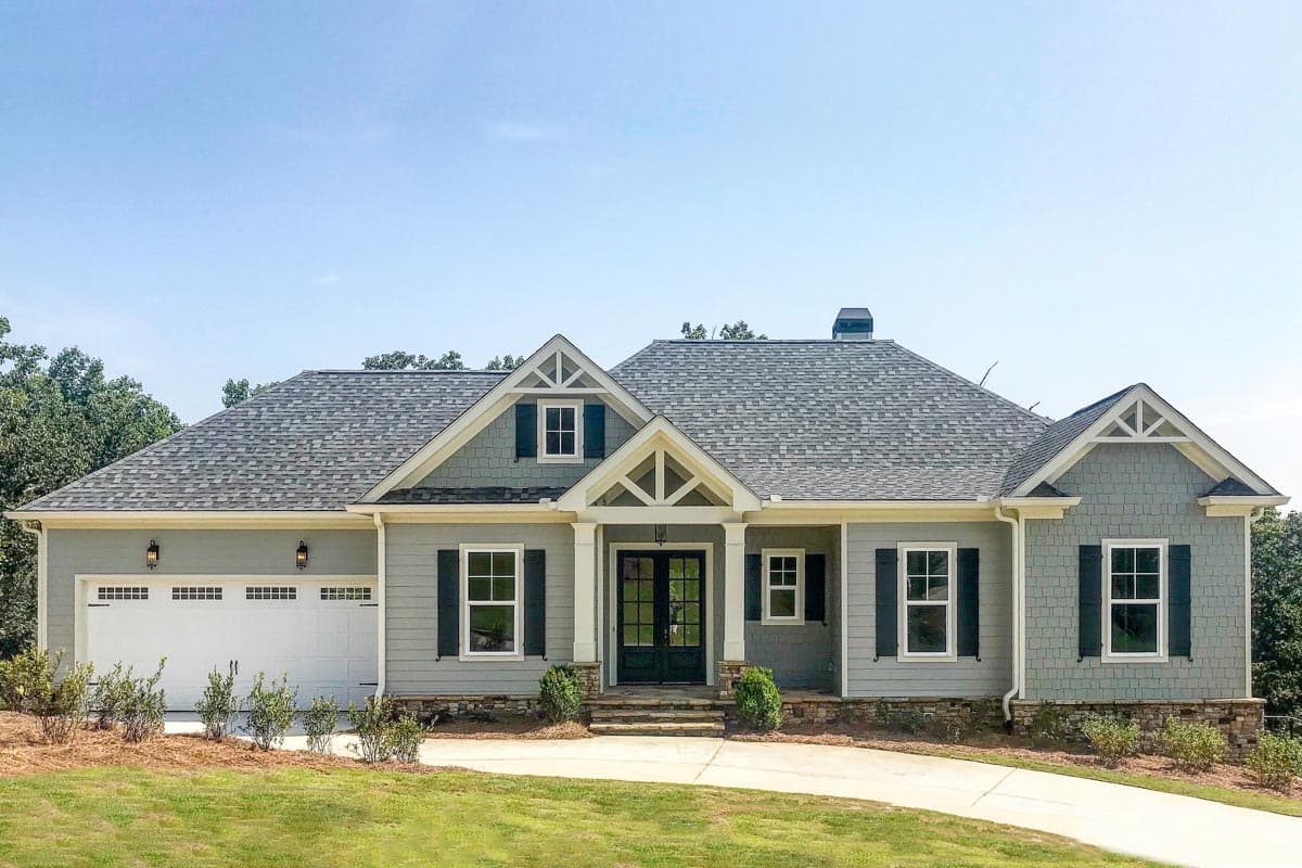 House plan exterior. Single-story Craftsman home with gabled roof, front porch with columns, and attached garage. Includes dormers and shutters.
