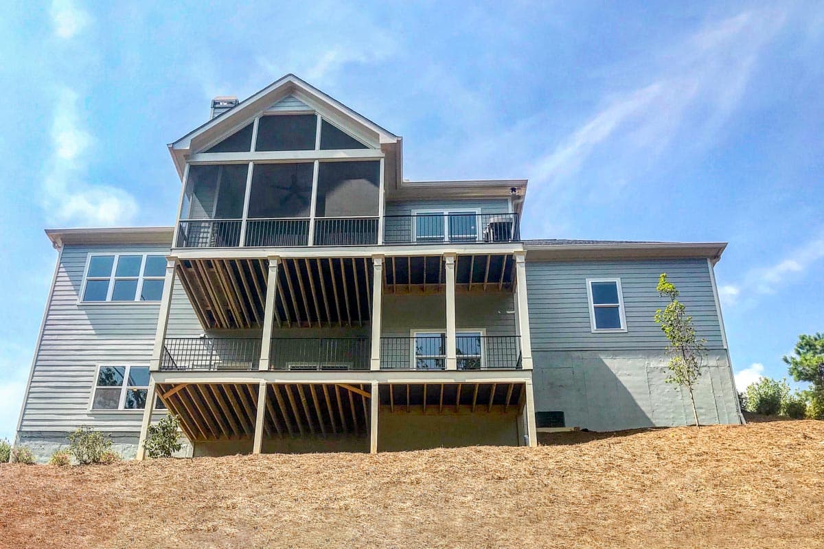 House plan exterior with multiple levels, screened porch, balconies, and siding.