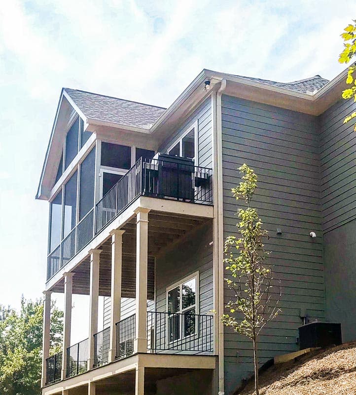 House plan exterior with screened porch, upper deck, and columns supporting lower porch.