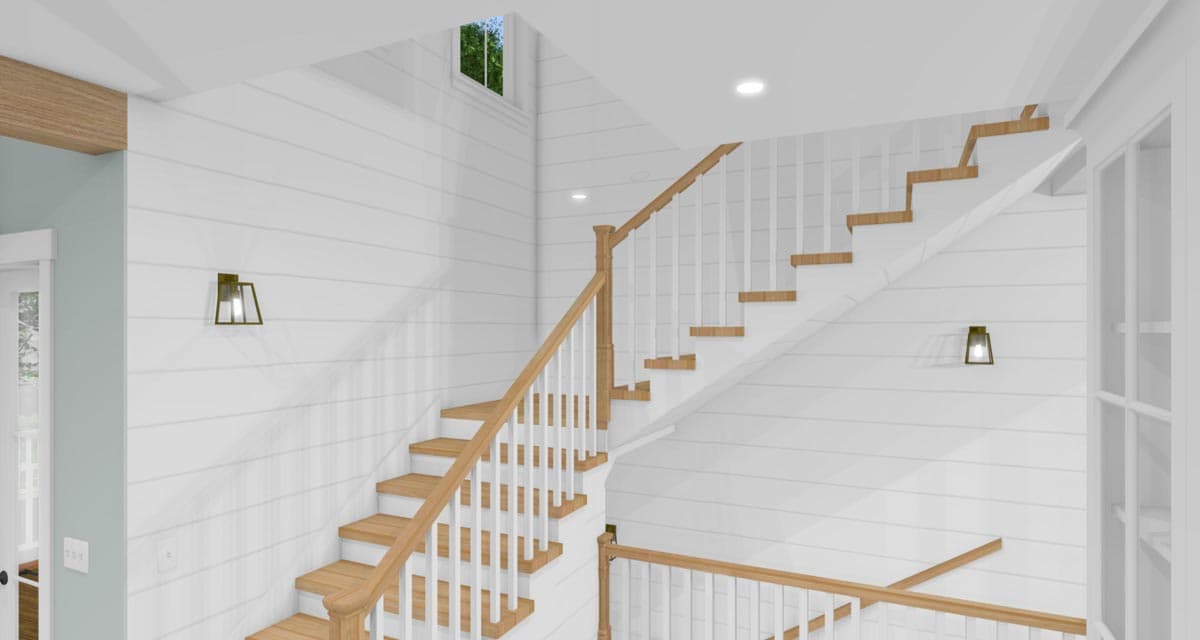 Interior staircase with white shiplap walls, wood treads, white balusters, and two brass lantern sconces.