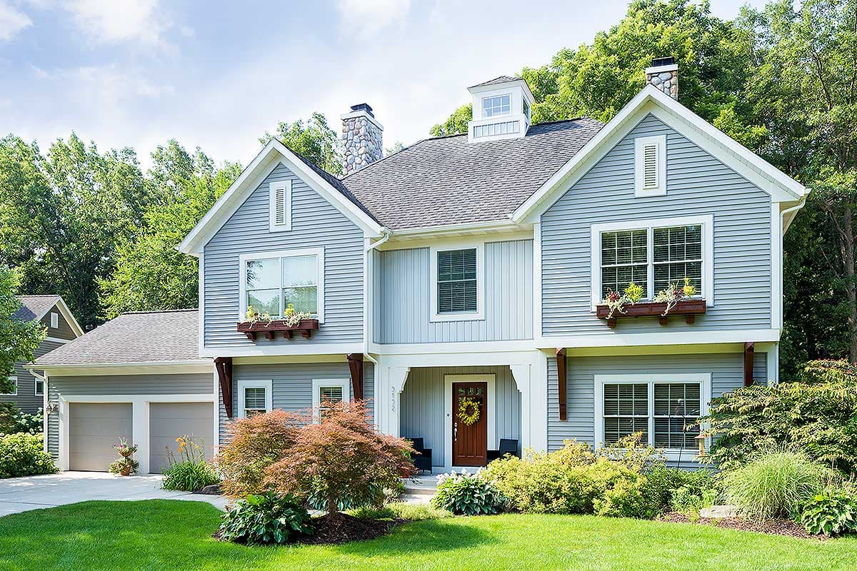 House plan exterior. Two-story home with Craftsman style. Features include gables, dormers, a front porch, and a detached two-car garage.