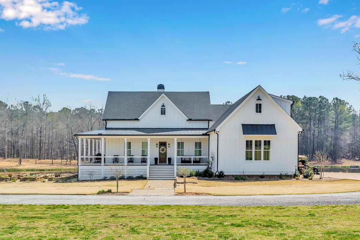 Modern farmhouse house plan exterior with wrap-around porch, board-and-batten siding, and prominent gables.