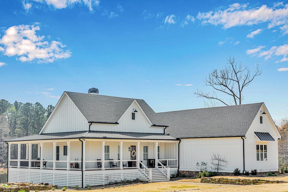 Modern Farmhouse exterior with wrap-around porch, board and batten siding, gables, and dormer windows.