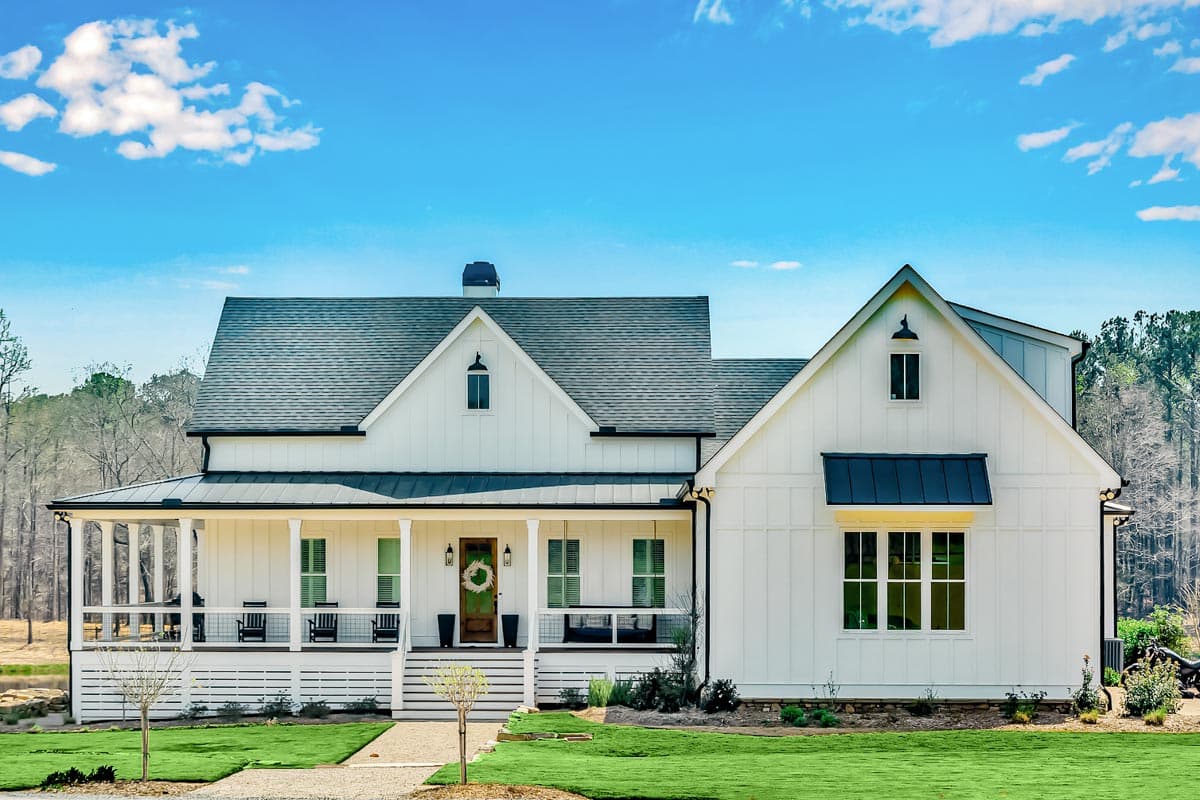 House plan exterior featuring a two-story Modern Farmhouse design. Includes a covered porch, multiple gables, and a dark metal roofline.