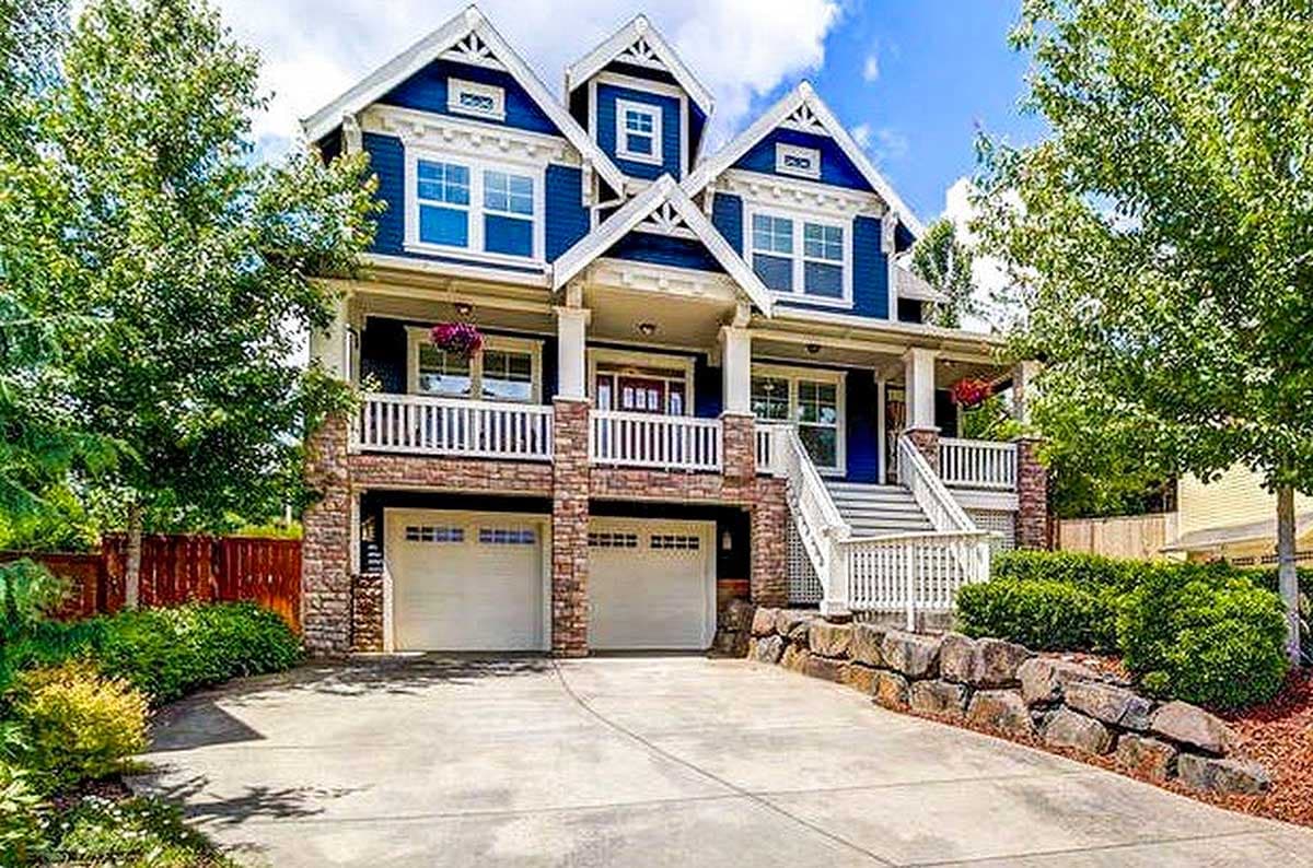 House plan exterior. Two-story Craftsman home with a porch, gabled roof, dormers, and a two-car garage under the front porch.