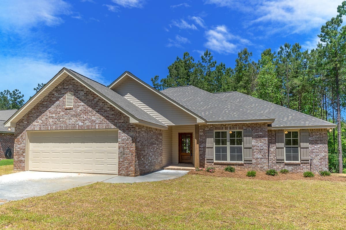 House plan exterior with brick facade, front-facing garage, gabled roof, and covered porch entry. Single story construction.