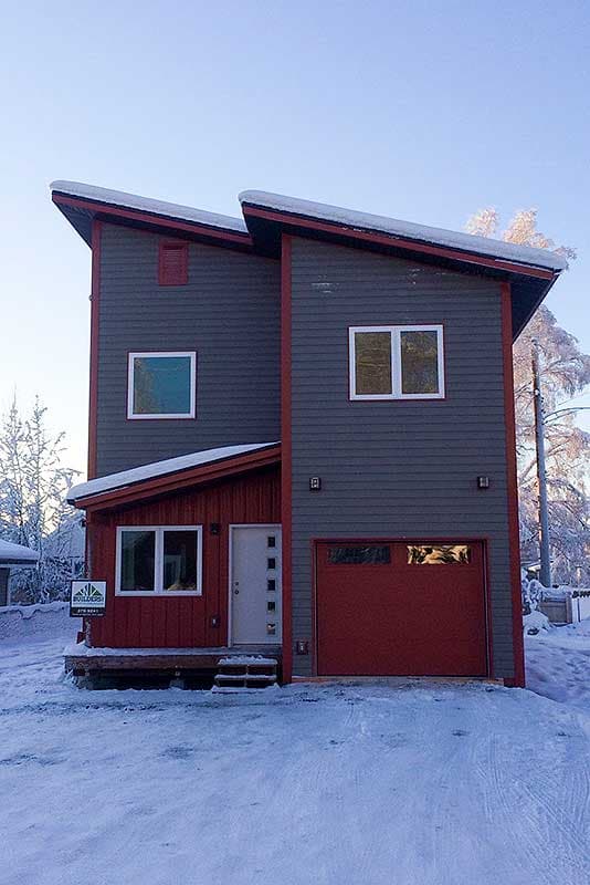 House plan exterior featuring a modern style with dual-pitched roof, contrasting siding, and a single-car garage.