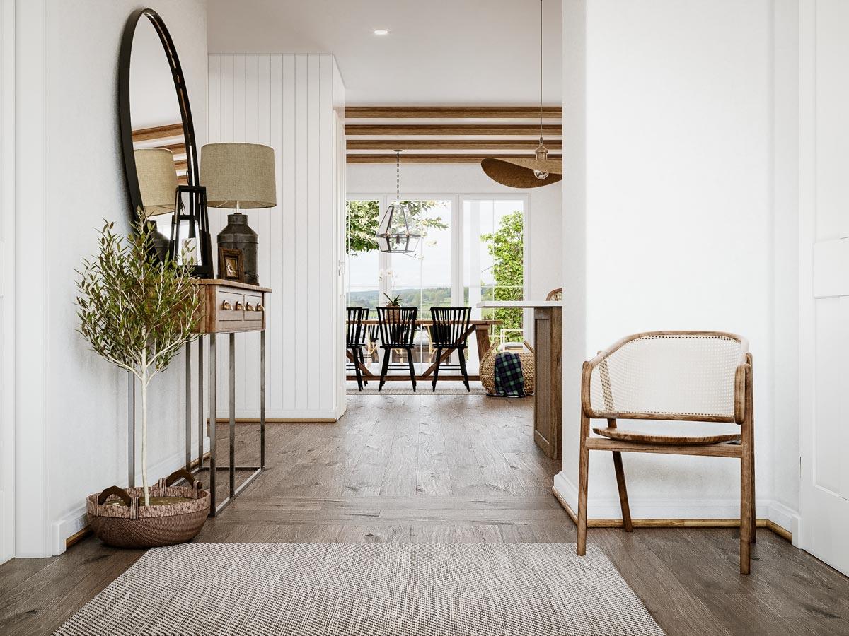 Interior view of a hallway leading to a dining area with wood beams, large windows, and a chair.