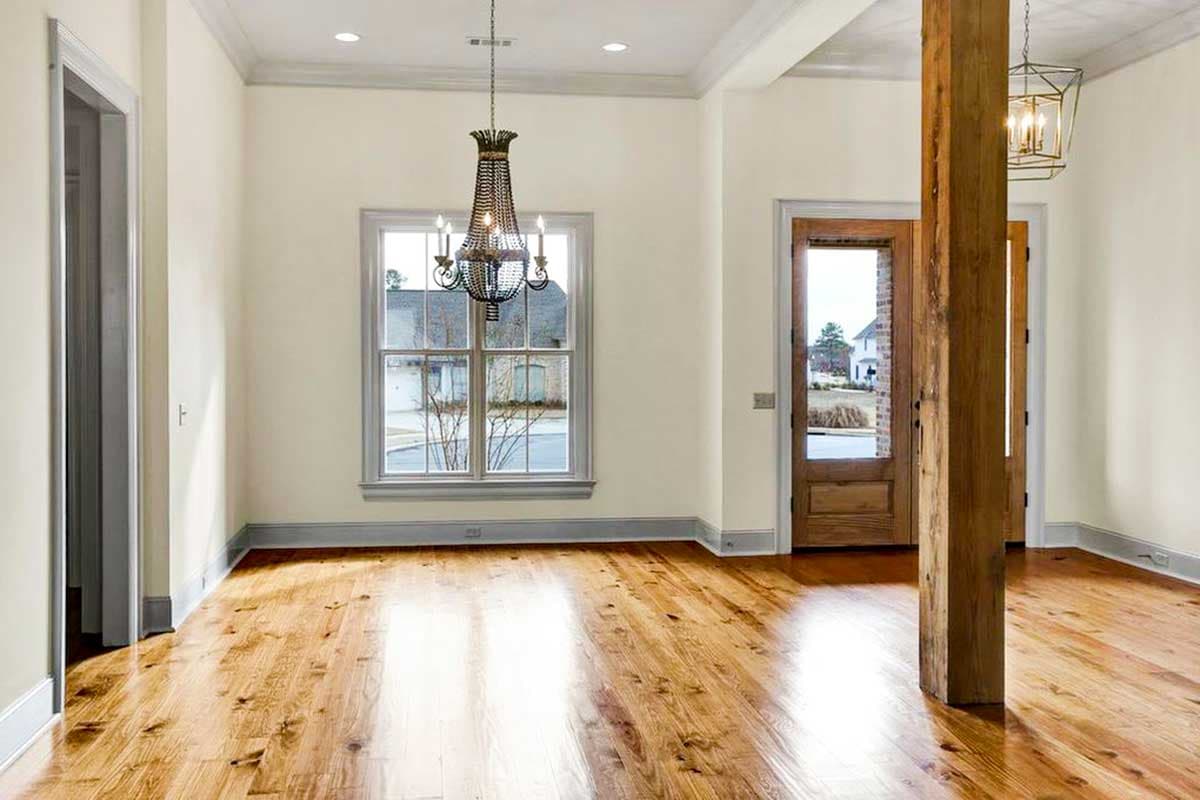 Interior view: Living area with hardwood floors, tray ceiling, decorative chandelier, and a rustic wood support beam.