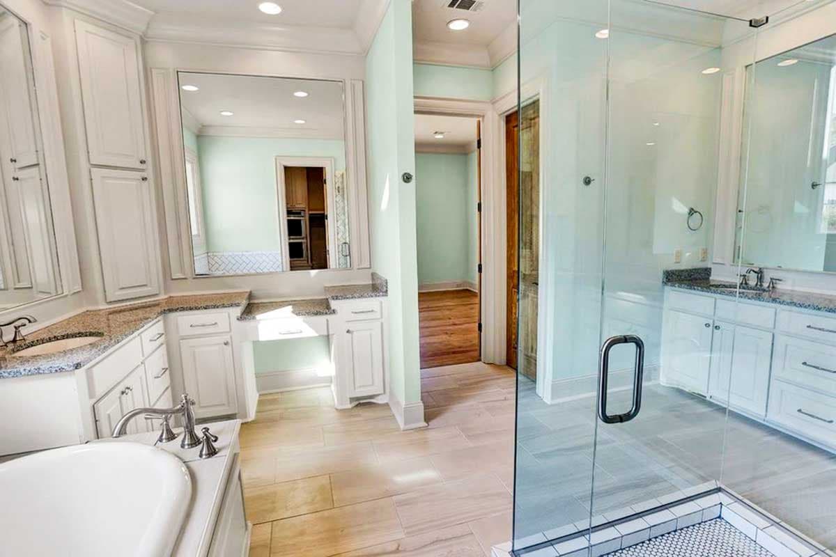 Primary bathroom with double vanity, freestanding tub, and glass-enclosed shower with tiled floor.