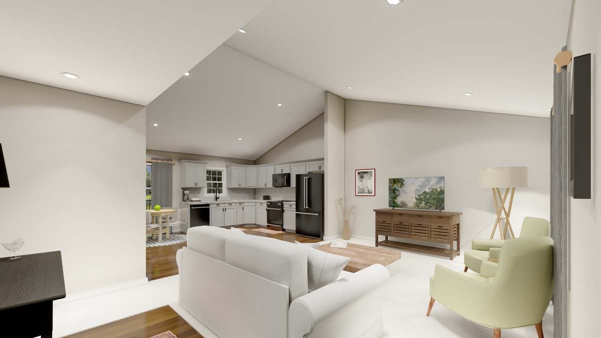 Open concept living area with vaulted ceiling, sofa, television, and adjacent kitchen with gray cabinetry and appliances.