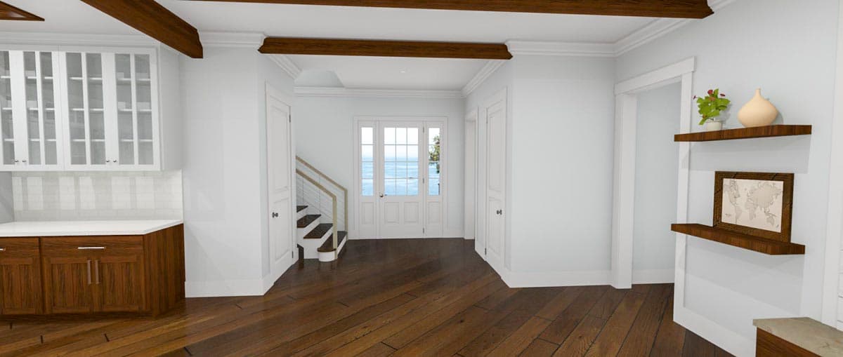 Interior view of a house: kitchen cabinetry, staircase, and double doors with ocean view.