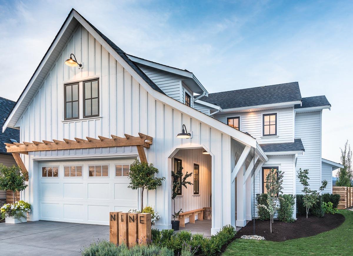 Modern Farmhouse exterior with two stories, gabled roof, pergola over garage, and covered entry porch with bench seating.