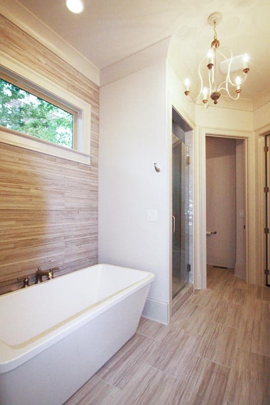 Bathroom with freestanding tub, glass shower enclosure, and chandelier.